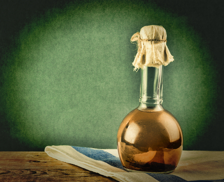 Old bottle with vegetable oil on a wooden tableの写真素材