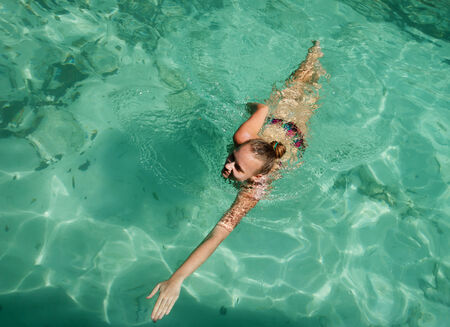 Young girl swimming in the turquoise water, Thailandの写真素材