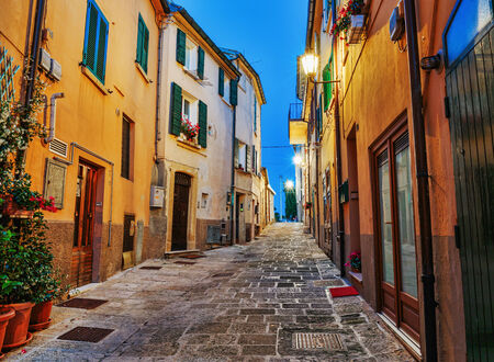 Narrow old street in Italy at nightの写真素材