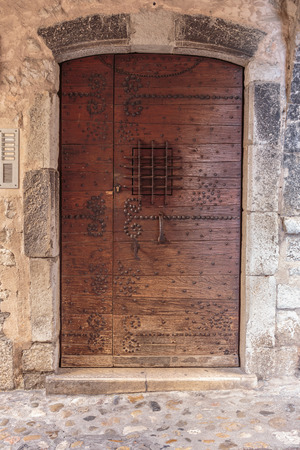 Old wooden door in the entrance stone French houseの写真素材