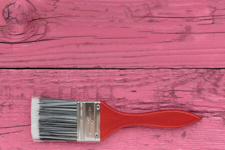 Paint brush on a wooden board pinkの写真素材