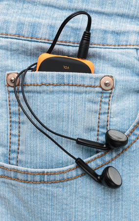 Player with headphones in the pocket of jeansの写真素材