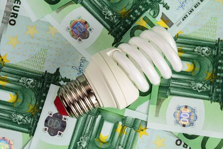 Energy saving light bulb on Euro banknotes