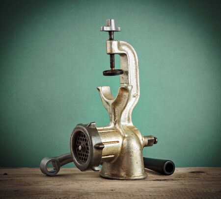 Old manual meat grinder on a wooden tableの写真素材