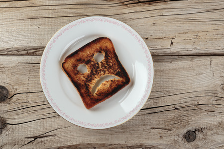 Sad toast on an old wooden boardの写真素材