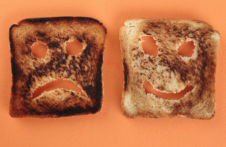 Happy and sad toast on a cutting boardの写真素材