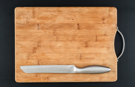 Kitchen cutting board and knife on a metal table