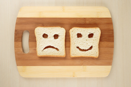 Happy and sad toast bread on a cutting boardの写真素材