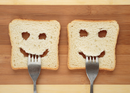Happy toast with a fork in her mouth on a cutting boardの写真素材