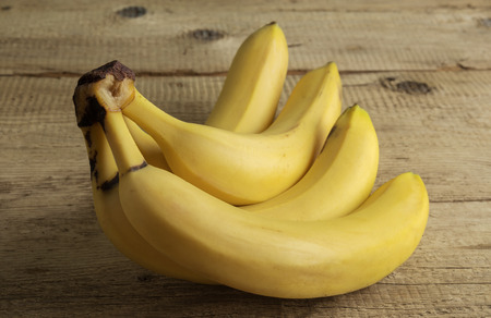 Ripe yellow bananas on old wooden boardsの写真素材