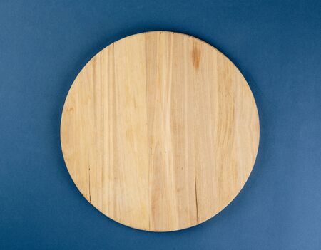 Round cutting board on a blue backgroundのeditorial素材