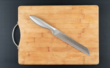Kitchen cutting board and knife on a metal tableの写真素材
