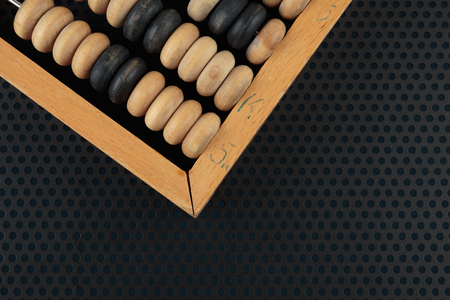 Old wooden abacus on a metallic background with perforation of round holes