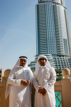 DUBAI, UAE - NOVEMBER 14: Two anonymous Arab men in traditional white clothing  looking at the Burj Khalifa on November 14, 2012, Dubai, UAE.のeditorial素材