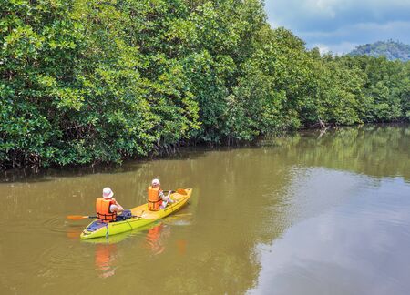 Tourists kayaking floating on the river in the jungles of Thailandの写真素材
