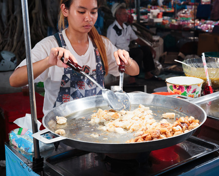 PATTAYA, THAILAND - APRIL 4, 2015: Woman in a street cafe fry foodのeditorial素材