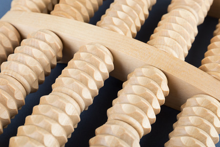 Wooden roller massage tool  for feet on a blue background