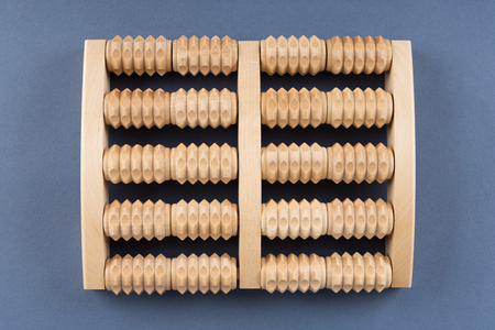Wooden roller massage tool  for feet on a blue backgroundの写真素材