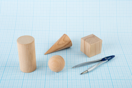 Wooden geometric shapes on graph paperの写真素材