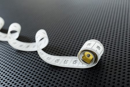 Curved white measuring tape on black background  perforatedの写真素材