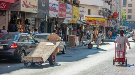 DUBAI, UAE-NOVEMBER 18, 2012: Man with a cart on the street in Dubaiのeditorial素材