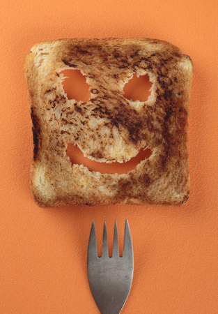 Happy toast and fork  on a  cutting boardの写真素材