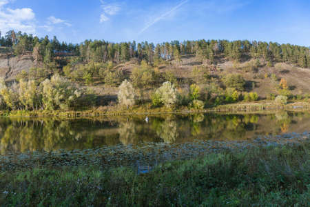 Fishermen in a boat on a lake in the countryside in autumn