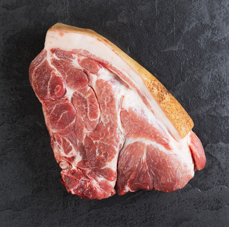 Piece of pork meat on the black stone tableの写真素材