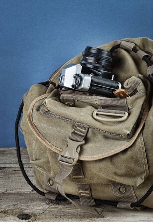 Old travel backpack  and camera on the wooden floorの写真素材