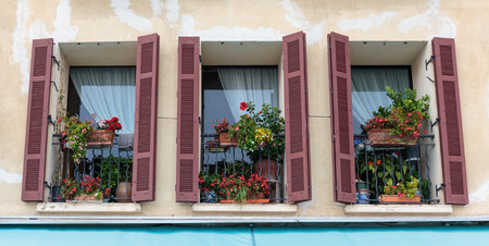 Windows in an old house decorated with flowersの写真素材