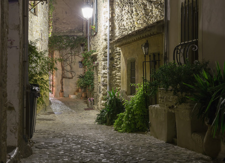 Narrow street in the old town in France at nightの写真素材