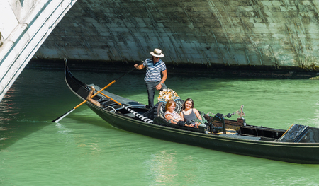 VENICE, ITALY - JUNE 26, 2014: Tourists float in gondola on canal in Veniceのeditorial素材