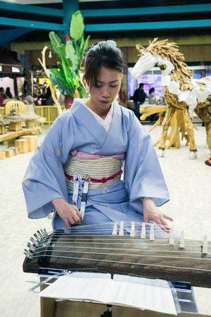 DUBAI, UAE - DECEMBER 4, 2017: Girl is playing a  traditional Japanese plucked instrument koto in the pavilion Japan of Global Villageのeditorial素材