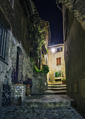 Narrow street in old town in France at nightの写真素材
