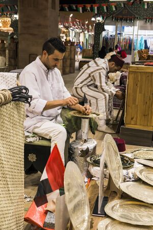 DUBAI, UAE - DECEMBER 4, 2017: Minter artisan in national clothes  in the pavilion of Turkey in Global Villageのeditorial素材