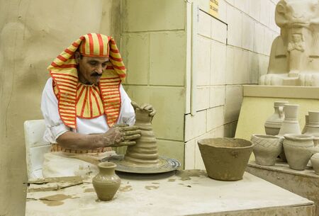 DUBAI, UAE - DECEMBER 4, 2017: Potter artisan in national clothes  in the pavilion of Egypt in Global Villageのeditorial素材