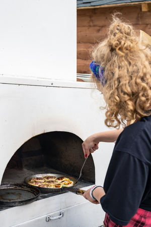 MOSCOW, RUSSIA - June 26, 2018: Baking small pizza in a traditional ovenのeditorial素材