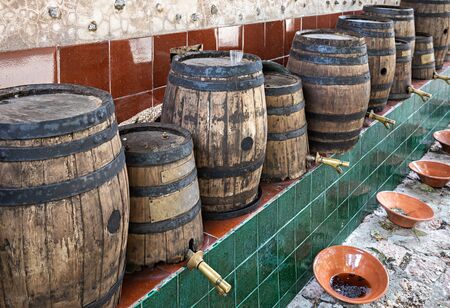 Old wooden barrels of wine for tasting at the winery