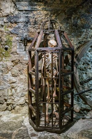 Medieval Metal cage with an old skeleton in the basement for tortureの写真素材