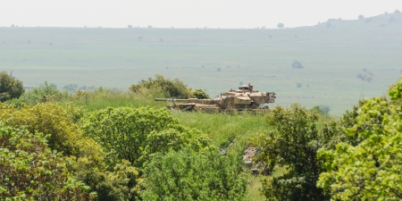 Israeli tank watch standby alert in high grass at boundary areaの写真素材