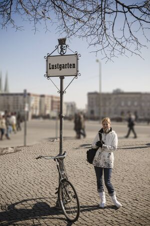 Modern woman with antique bike on Lustgarten square (Pleasure Garden) in the center of Berlin. Retro vintage stylish photo.の写真素材