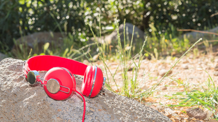 Bright red wired headphones on the rock with free place for your textの写真素材