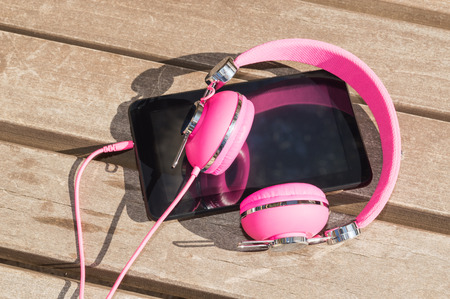 Modern style of distance mobile language study for girls: pink headphones and tablet pcの写真素材