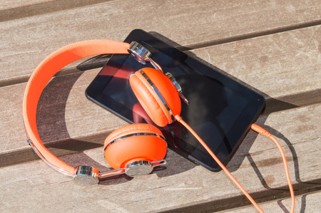 Orange headphones and tablet pc for mobile audio language course learning の写真素材