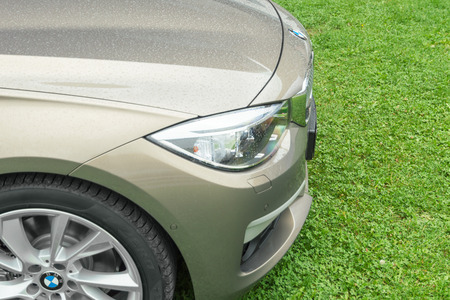 MUNICH, GERMANY - AUGUST 9, 2014: New model of BMW prestigious business car on fresh green grass wet after rain. Close-up details.のeditorial素材