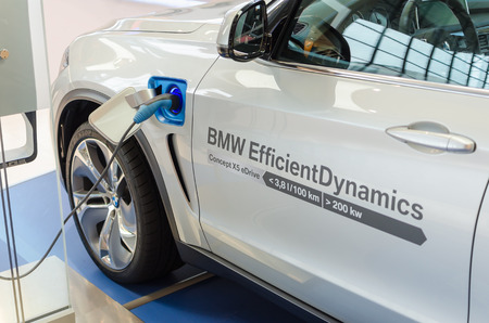 MUNICH, GERMANY - AUGUST 8, 2014: New model of environmentally friendly electric car BMW x5 with hybrid engine at charging station.のeditorial素材