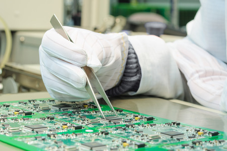 Quality control and assembly of SMT printed components on circuit board in QC lab of PCB manufacturing high-tech factoryの写真素材