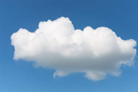One single fluffy Cumulus cloud in clear deep blue summer skyの写真素材