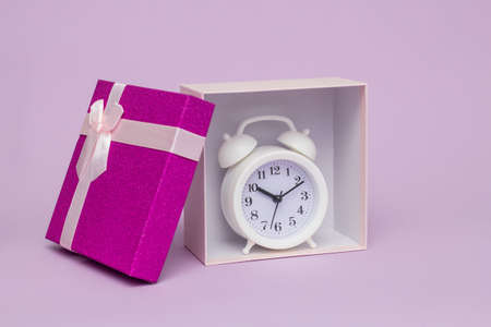 white alarm clock in a gift box for the holidayの写真素材
