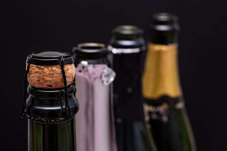 Close up of the neck champagne bottle with three open bottles on a blurredの写真素材